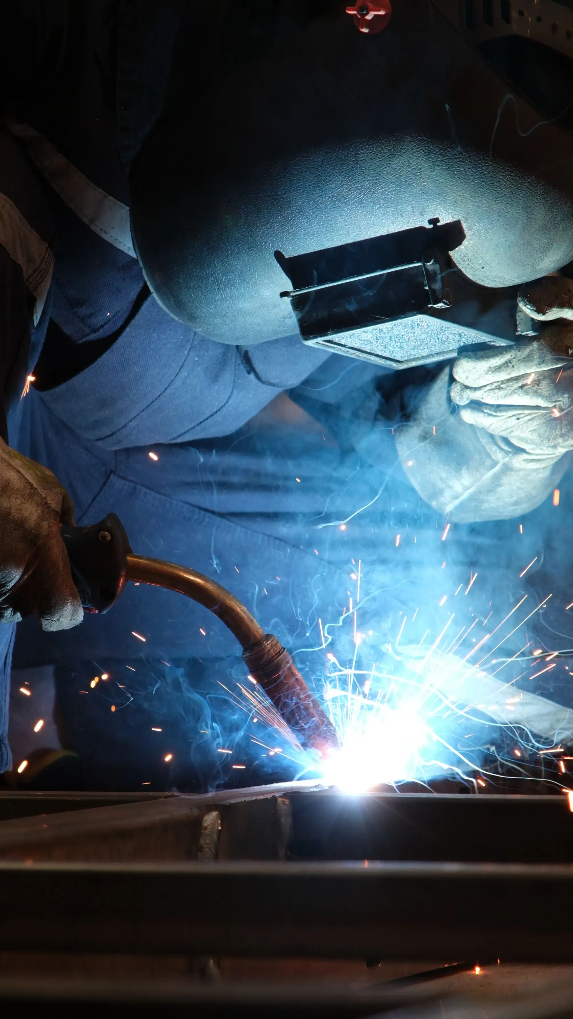 Soldador trabajando con máscara de protección